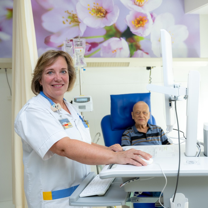 Angela Jansen aan het werk op de computer bij een patiënt op de dagbehandeling Oncologie. Foto: Toon Hendriks