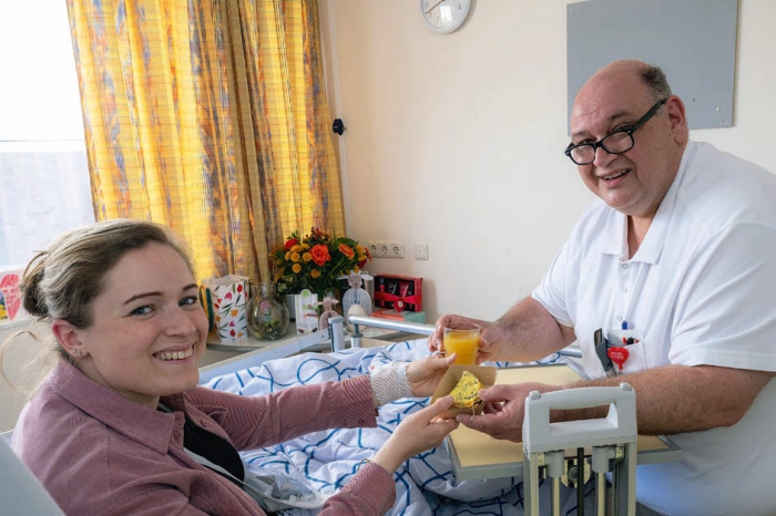 Medewerker gastenservice René overhandigt een smakelijk en gezond tussendoortje aan patiënte Femke .