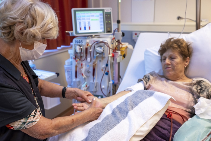 Vrijwilliger Ilse Lap-Celis masseert de handen van mevrouw W. Keuben tijdens de dialyse.