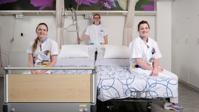 Een ziekenhuisbed (links) gekoppeld met een koppelbed. Met van links naar rechts de verpleegkundigen Celine Bloemers, Dian Lenselink en Jeanine Messing.